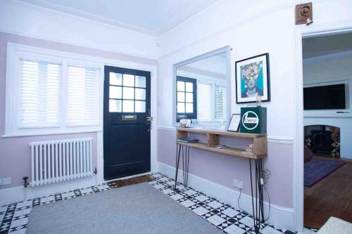 a room with a black door and a mirror at Seafront home with fabulous sea views in Herne Bay