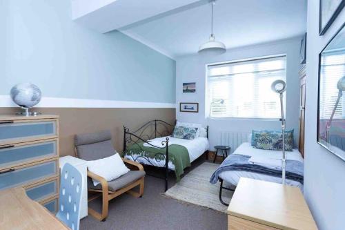 a small room with two beds and a couch at Seafront home with fabulous sea views in Herne Bay