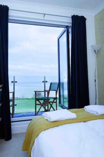 a bedroom with a bed and a large window at Seafront home with fabulous sea views in Herne Bay
