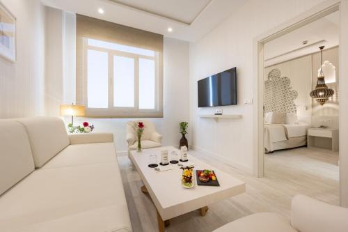 a white living room with a white couch and a table at Hotel Saray in Granada