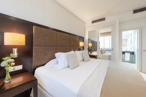 a bedroom with a large white bed with white pillows at Hotel Saray in Granada