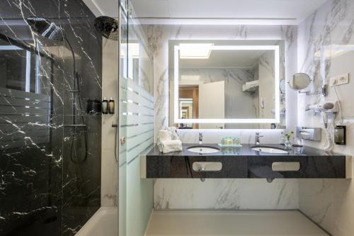 a bathroom with two sinks and a mirror at Hotel Saray in Granada