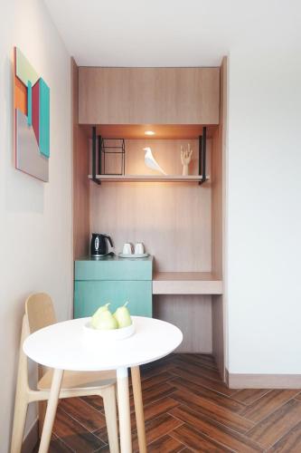 a small kitchen with a white table and a table and chairs at SQ Boutique Hotel in Bangkok