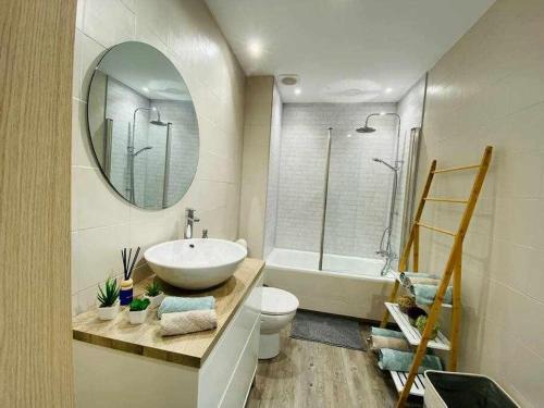 een badkamer met een wastafel, een toilet en een spiegel bij Playa Fantástico apartamento Playa a 150m in Fuengirola