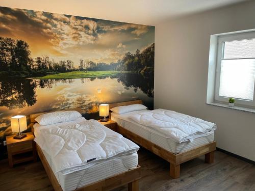 2 camas en una habitación con un cuadro en la pared en Ferienhaus Deichgraf Gatow, en Pinnow