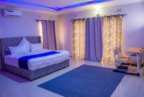 a bedroom with a bed and a table and chairs at Gatoma Executive Lodge in Lusaka