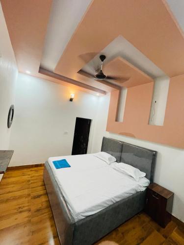 a large bed in a room with a ceiling at Shimmer Farms in Faridabad