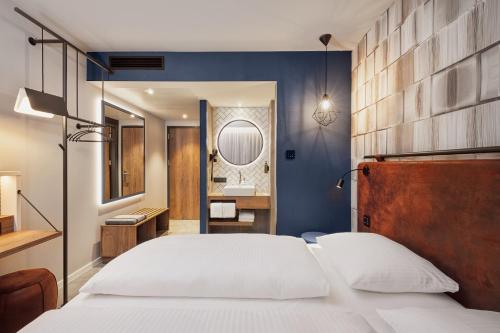 a bedroom with a large bed and a bathroom at H2 Hotel Mainz in Mainz