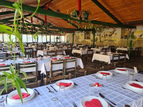 a restaurant with white tables and chairs with red napkins at Guljaš Čarda Old in Šupljak