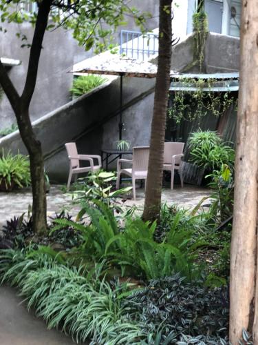 un jardín con sillas, árboles y plantas en the APARTMENT house, en Mbale