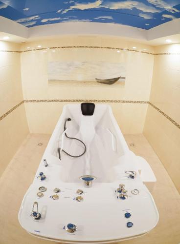 a white sink in a room with a boat on the wall at GRAND OTRADA Hotel Resort & SPA in Odesa