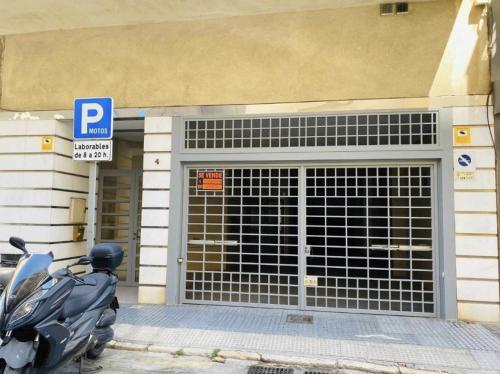 uma moto estacionada em frente a uma garagem em Holidays2Malaga Train Station Area em Málaga