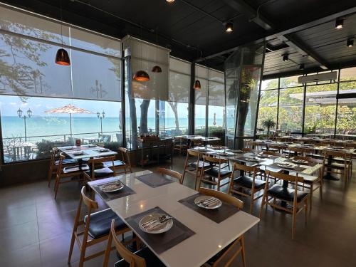 a restaurant with tables and chairs and large windows at Majestic Residence 2Bedroom PoolVilla51, Beach Gate in Pattaya South