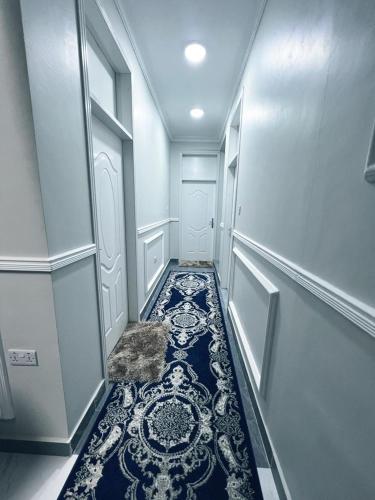 a hallway with a blue and white tile floor at Greenlight Apartments in Kiembi Samaki