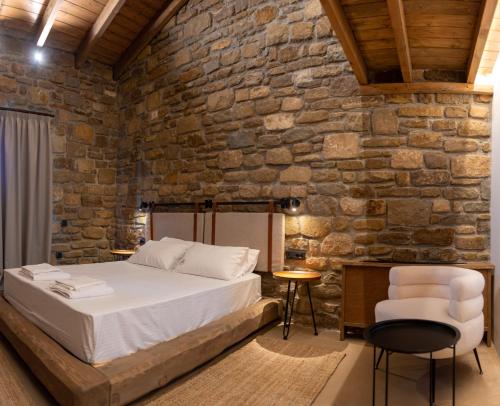 a bedroom with a bed and a stone wall at Άνδηρο in Synikia Mesi Trikalon