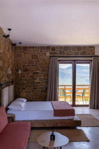 a bedroom with two beds and a brick wall at Άνδηρο in Synikia Mesi Trikalon