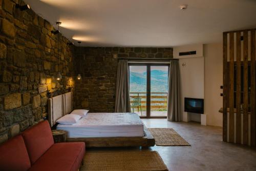 ein Schlafzimmer mit einem Bett, einem Sofa und einem Fenster in der Unterkunft Άνδηρο in Synikia Mesi Trikalon