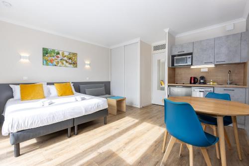 1 dormitorio con 1 cama, mesa y sillas en Star Of Life en Courbevoie
