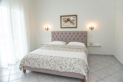 a bedroom with a large bed in a white room at TheasHomly in Kastanéa
