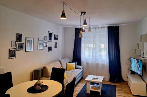 ein Wohnzimmer mit einem Sofa und einem Tisch in der Unterkunft Gospic Riverside Apartment in Gospić