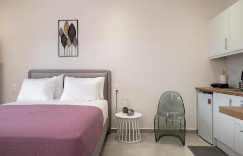 a bedroom with a bed and a table and a chair at KA Luxury Apartments in Mantoúkion