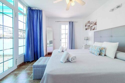 a bedroom with a large bed with blue curtains at Casa Tauro in Adeje