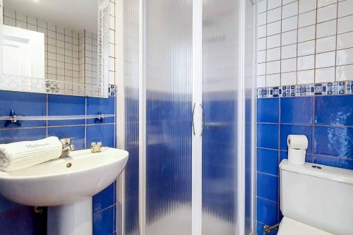 a blue and white bathroom with a sink and a toilet at Casa Tauro in Adeje