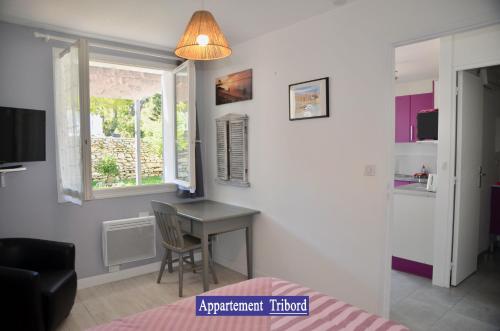 1 dormitorio con escritorio, ventana y cama en Villa des 4 saisons, en Saint-Trojan-les-Bains