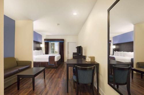 a hotel room with a bed and a mirror at Days Inn & Suites by Wyndham Galveston West/Seawall in Galveston