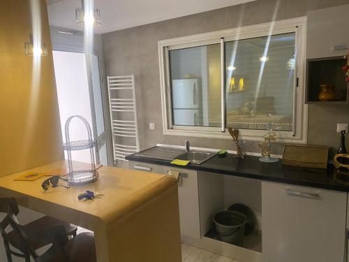 a kitchen with a counter and a sink and a window at Superbe appartement sahloul 4 in Sousse