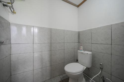 een badkamer met een wit toilet in een kamer bij Volcano Cabin Batur RedPartner in Baturaja