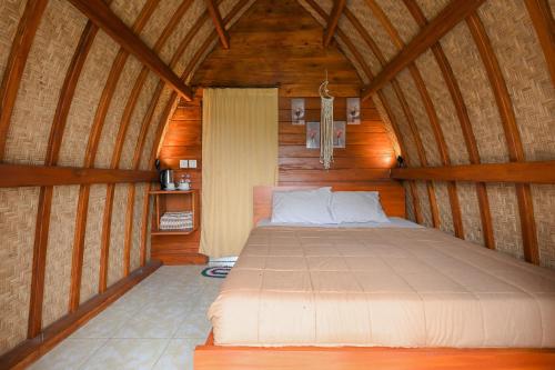 a bedroom with a bed in a wooden room at Volcano Cabin Batur RedPartner in Baturaja