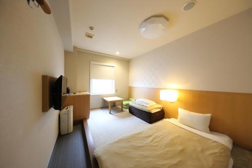 a hotel room with a bed and a television at Smile Hotel Kyoto Karasuma Gojo in Kyoto
