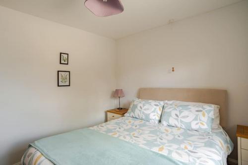 a bedroom with a bed with a blue comforter at Tanglewood in West Ashton