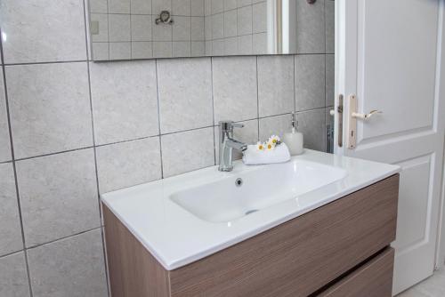 a bathroom with a white sink and a mirror at TheasHomly in Kastanéa