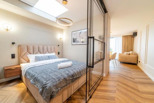 a bedroom with a large bed with a glass wall at Lake Rental Pratum 24 in Mikołajki