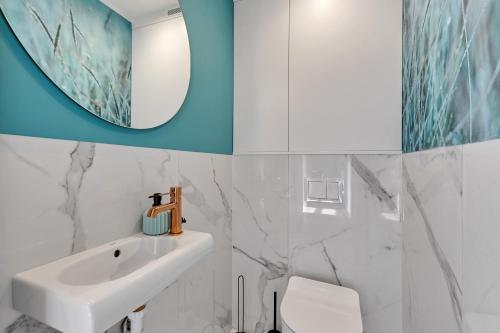 bagno con lavandino bianco e specchio di Dom & House - Apartament Kościuszki Family a Sopot