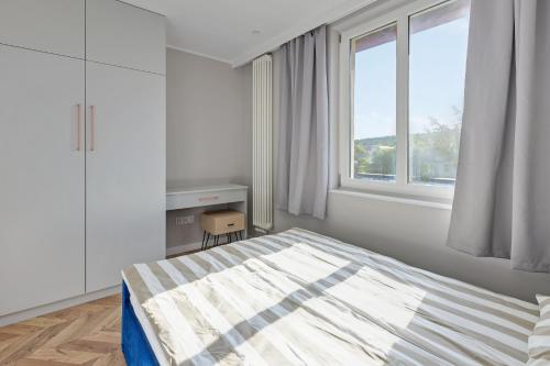 una camera bianca con un letto e una finestra di Dom & House - Apartament Kościuszki Family a Sopot