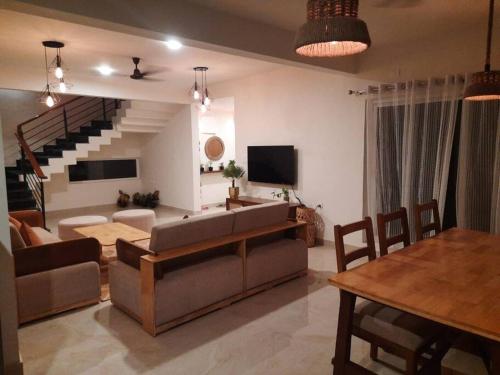 a living room with a couch and a table at The RusticVibe-Villa with Garden 30 km frm Ecity in Bangalore