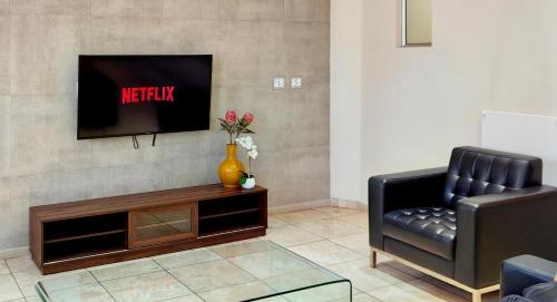 a living room with a black chair and a television at 4 on Pritchard Luxury Suites in Johannesburg