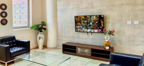 a living room with a tv on a wall at 4 on Pritchard Luxury Suites in Johannesburg