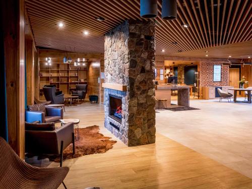 a lobby with a stone fireplace in a room at Mercure Karpacz Skalny in Karpacz