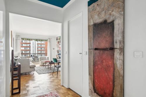 une porte donnant sur un salon avec un tableau au mur dans l'établissement Boulogne Billancourt - Chateau 1 bdr, à Boulogne-Billancourt