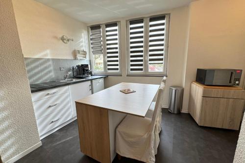 a kitchen with white cabinets and a counter top at Côté jardin appartement centre Gramat in Gramat