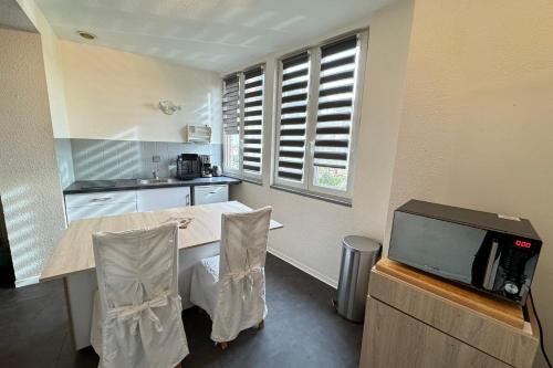 a kitchen with a table and a tv at Côté jardin appartement centre Gramat in Gramat
