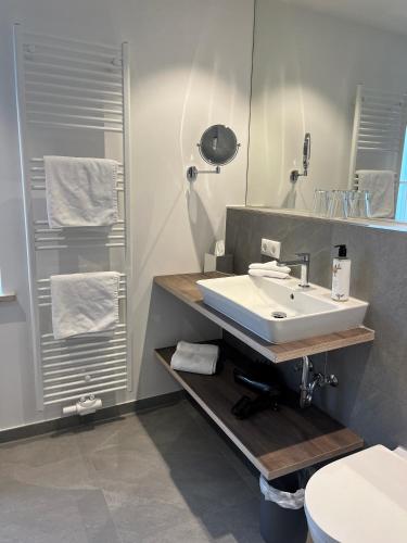 a bathroom with a white sink and a mirror at Hotel zur Sonne in Rimsting