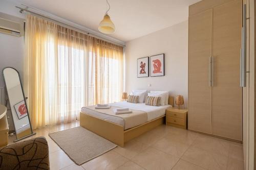 a bedroom with a bed and a large window at Villa Serenity in Ialyssos