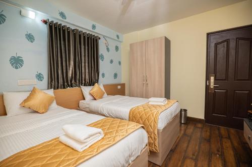 a bedroom with two beds and a window at Guesture Stays - Dwellington, Electronics City Phase 2 in Bengaluru