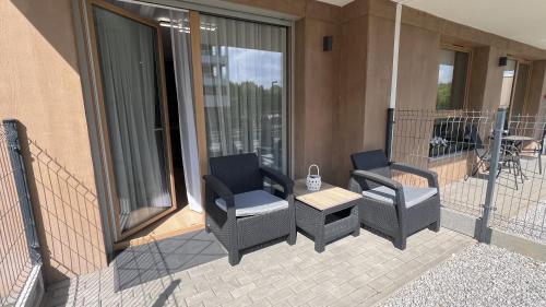 a patio with chairs and a table and a balcony at Apartament Poleska in Częstochowa