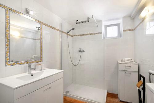 ein weißes Bad mit einer Dusche und einem Waschbecken in der Unterkunft Quinta de Loubite - Laranjeiras in Lagoa